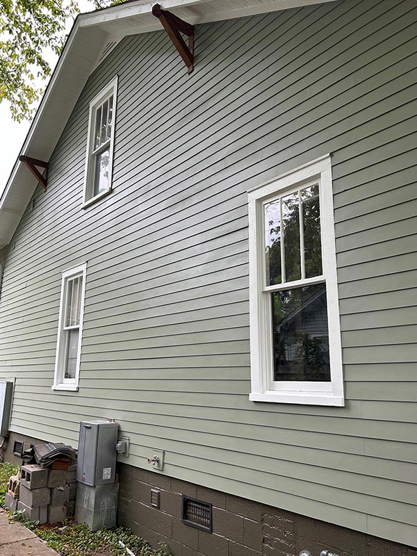Siding Installation on the Side of a two story home with green siding
