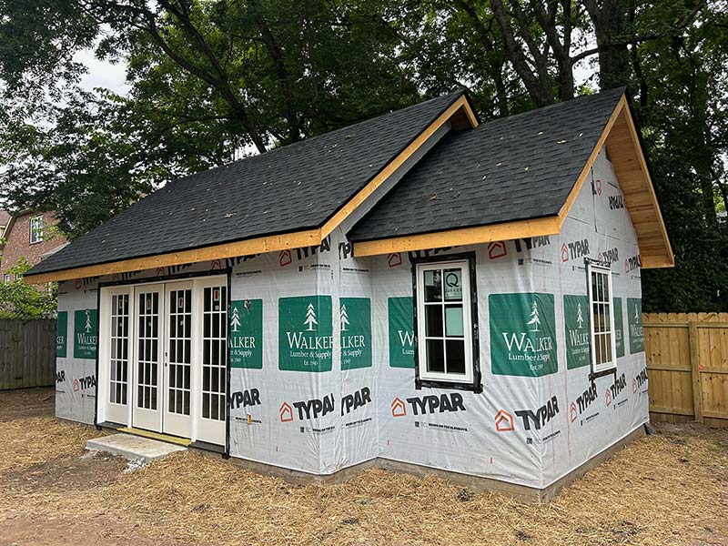 A small home is being prepared for new siding with tyvek wrapping