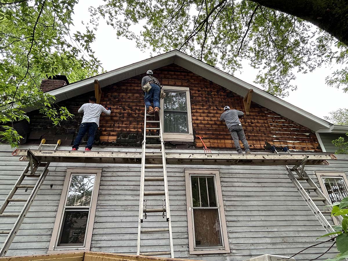 The Illinois Project - Located in The Nations Neighborhood in North West Nashville - Before image showing the crew working on peeling off the old siding