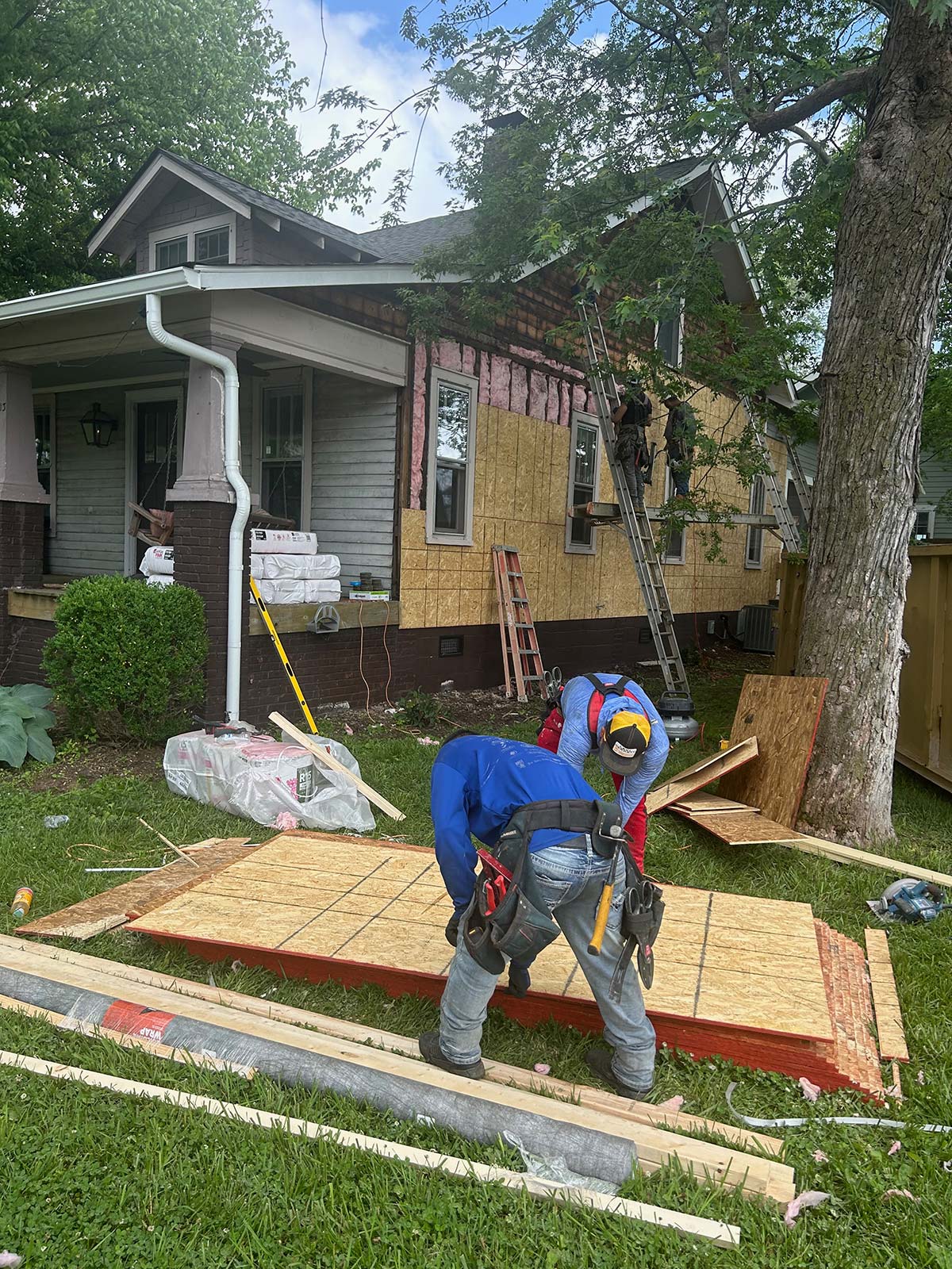 The Illinois Project - Located in The Nations Neighborhood in North West Nashville - Before image showing the crew working on peeling off the old siding on ladders
